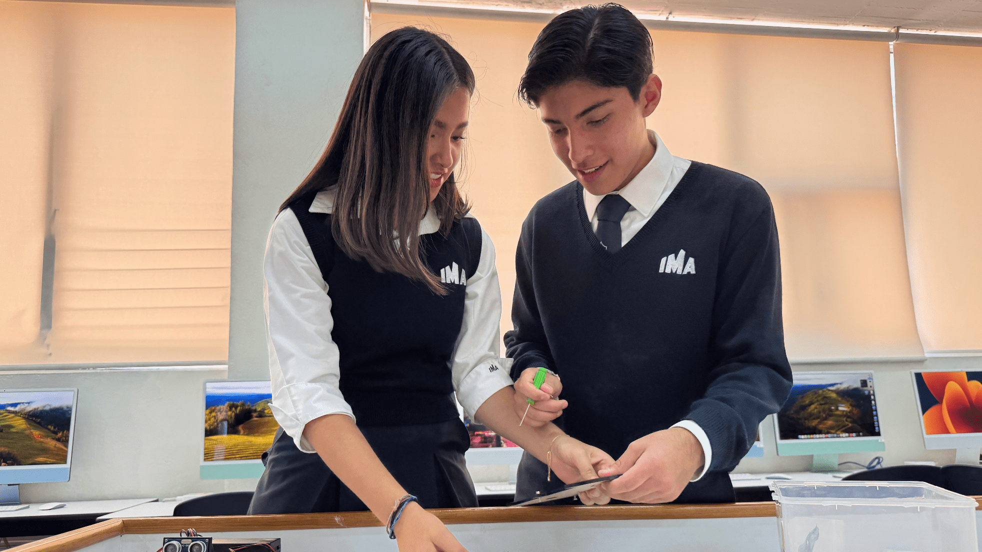 Alumnos de preparatoria IMA en el aula de robótica con kits educativos